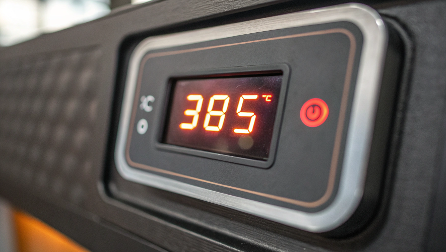 A close-up shot of a digital heat press controller, with the temperature clearly displayed as 385°F.