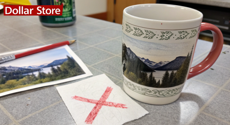A picture of a dollar store mug with a piece of sublimation paper next to it, where the ink has clearly not transferred, with a large red "X" over the image.